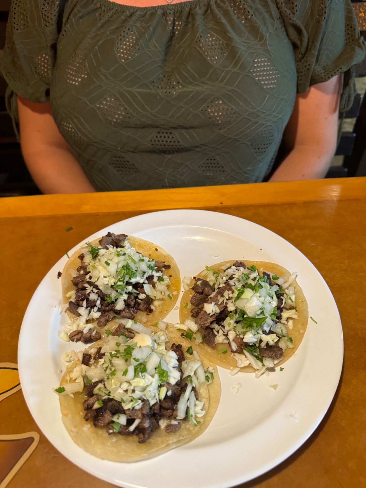 Three carne asada tacos with cilantro and onion