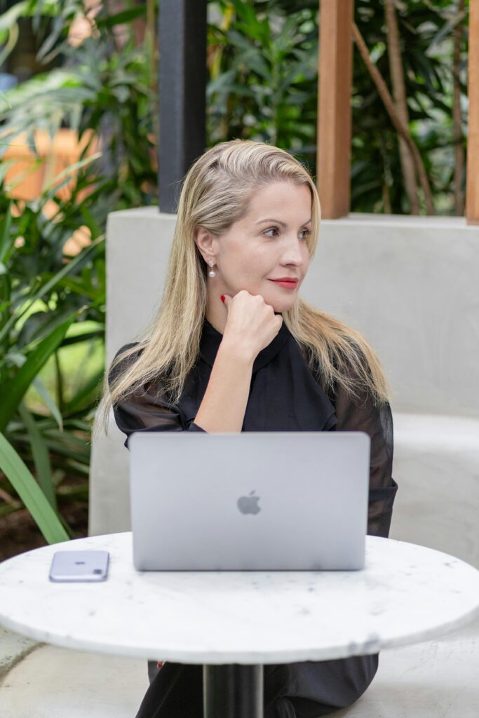 Person working on a laptop at a cafe table with a smartphone