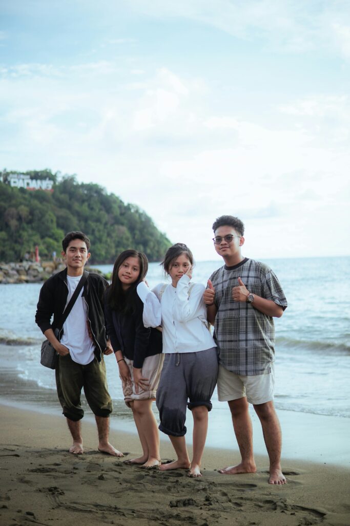 Group of friends standing on a beach posing for a photo
